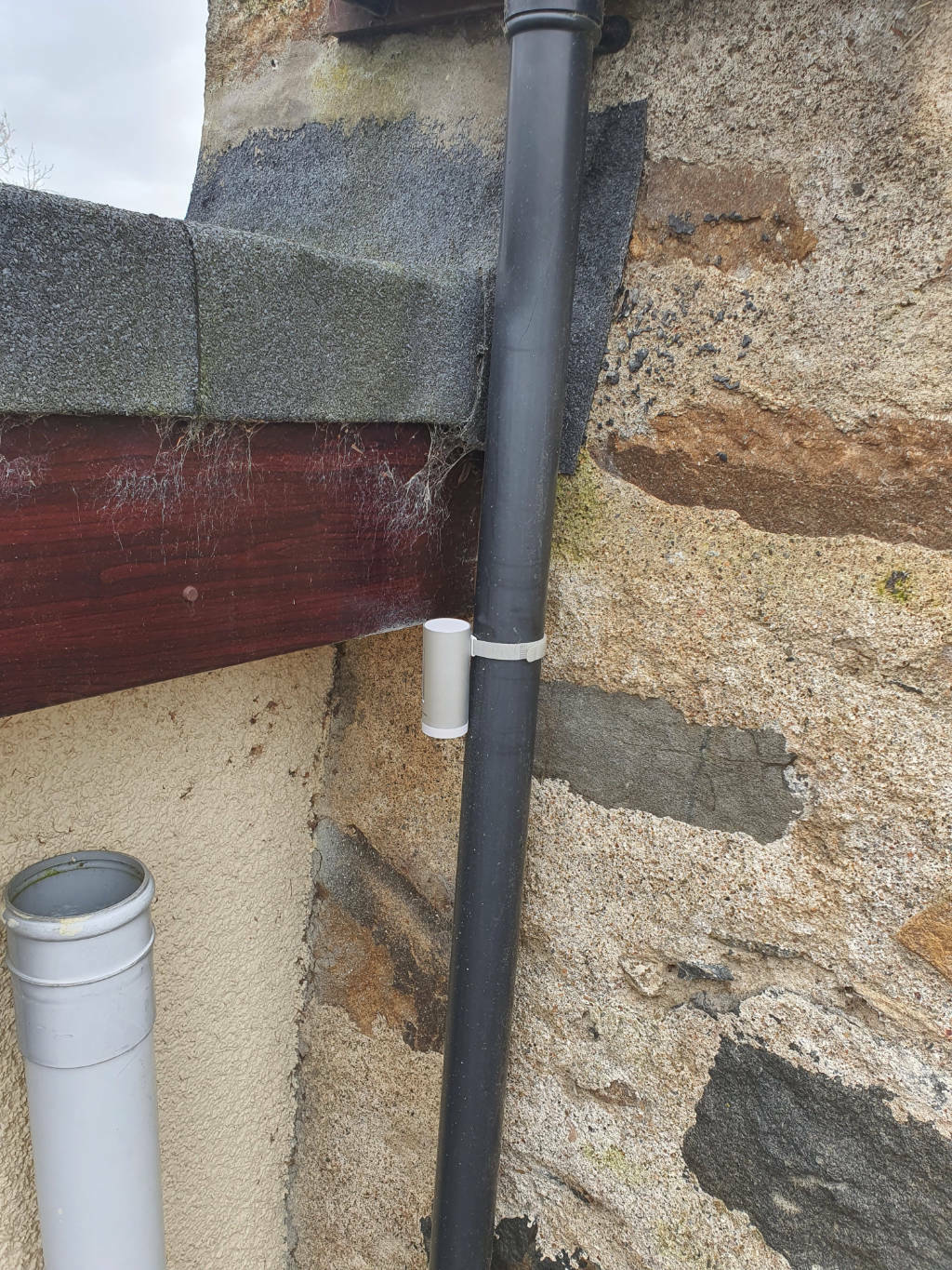 Photo of the Netatmo outdoor unit mounted to a drain pipe